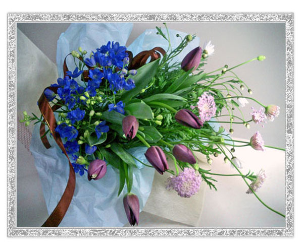 春のイメージのお花を落ち着いた色合いでまとめた花束です。ちょっと子供っぽい印象のチューリップも紫だととってもエレガントなイメージです。 お誕生日のお祝いや季節のごあいさつに。また、紫のチュウリップ花言葉のイメージから、ご結婚やご婚約の記念日のプレゼントにもおすすめです。花言葉を添えていかがでしょうか。 リボンの色のご指定も可能ですのでシチュエーションや、お届け先様のイメージに合わせてお選びください。
